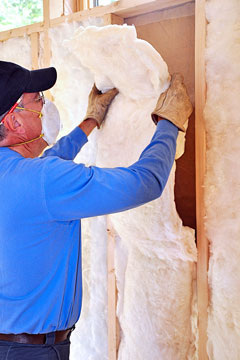 an insulation worker installing fiberglass insulation